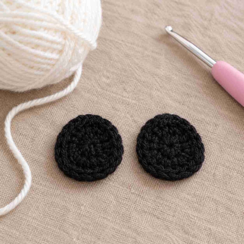 Black crochet eye patches for amigurumi panda before sewing on